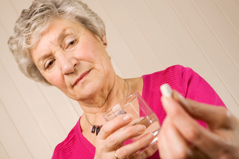older woman with pill and water glass.jpg